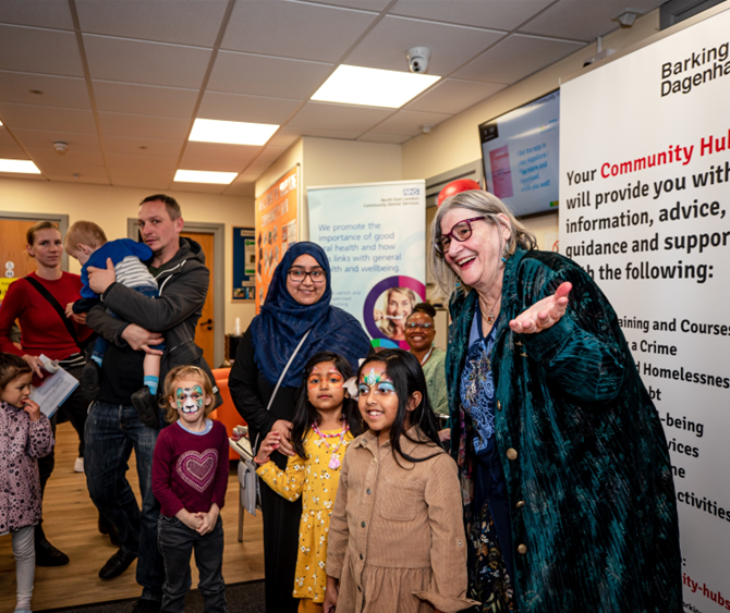 A group of people, including children with face paint, at the Village Community Hub